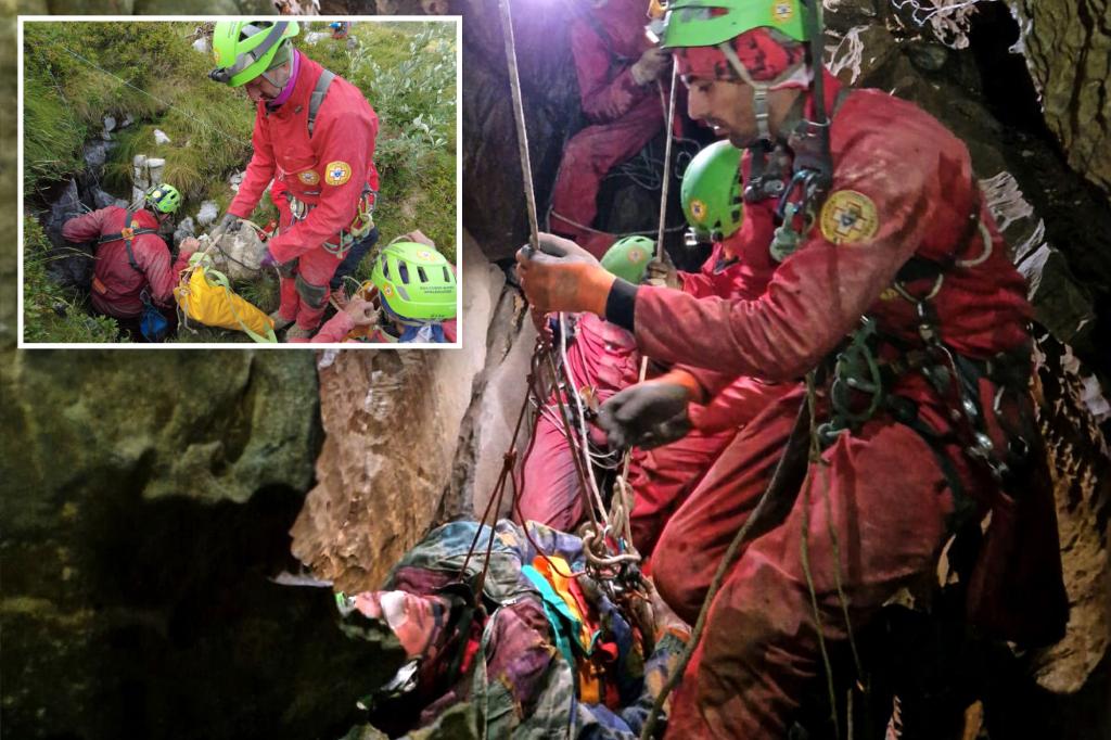 Rescuers work to free an injured cave explorer trapped more than 130 feet underground in Italy