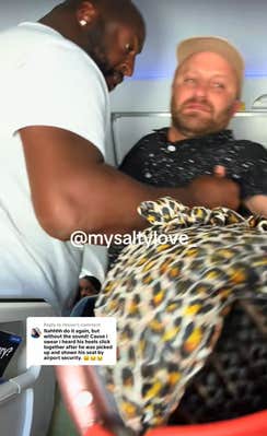 A big man picking up an unruly drunk man on a plane and forcing him to sit back down.