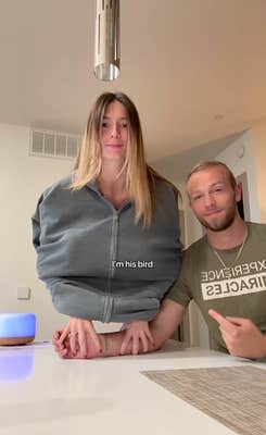 A couple doing the bird trend in a kitchen.