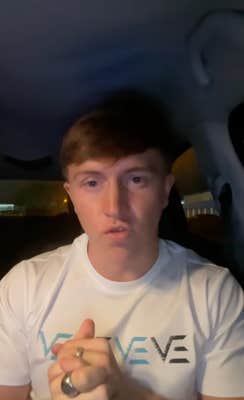 A young man grasping hands together, sitting in his car as he explains what happened.