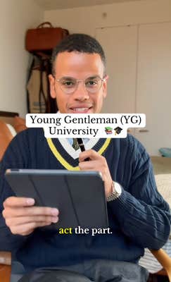 A Black man in a fancy sweater and glasses holding an iPad prompter for his recording.