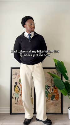 A Black man dressed up in a quarter-zip sweater and chinos.