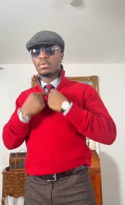 The same Black man dressed in a dapper outfit complete with quarter-zip sweater.