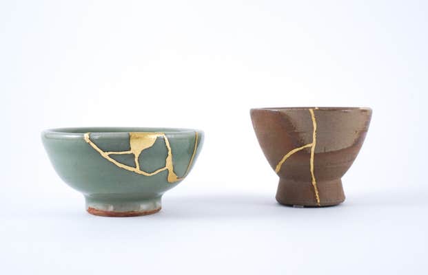 two ceramic pots with gold holding pieces together