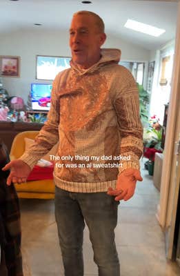 TikTok video with a man spreading his arms in a tan tree sweater with a caption reading, "The only thing my dad asked for was an ai sweatshirt."