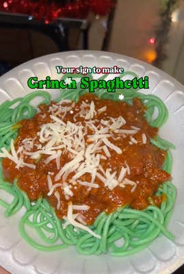 @amandaaa_ann/TikTok green spaghetti with sauce on a plate with onscreen text: "Your sign to make Grinch Spaghetti"