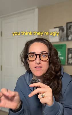 Woman with long brown hair and big glasses holding a lapel mic in her hand and talking to the camera in her home. Text overlay reads, "you think they're ugly."