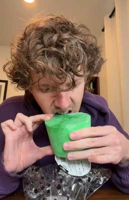 TikTok video of a man biting into a large green horse treat in his home.
