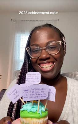 @bytesofbree/TikTok woman holds up achievement cake with notes stuck in it